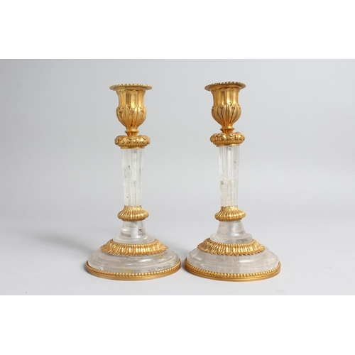 1273 - A PAIR OF GILT BRONZE MOUNTED ROCK CRYSTAL CANDLESTICKS. 7.5ins high.