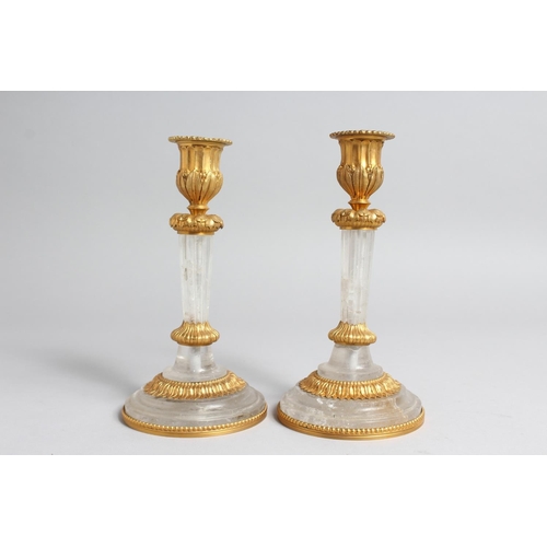 1273 - A PAIR OF GILT BRONZE MOUNTED ROCK CRYSTAL CANDLESTICKS. 7.5ins high.