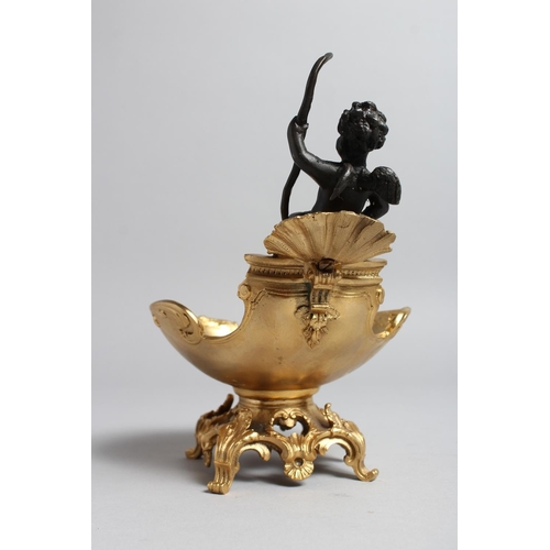 1274 - A GILT BRONZE TABLE SALT mounted with a cherub. 7ins high.