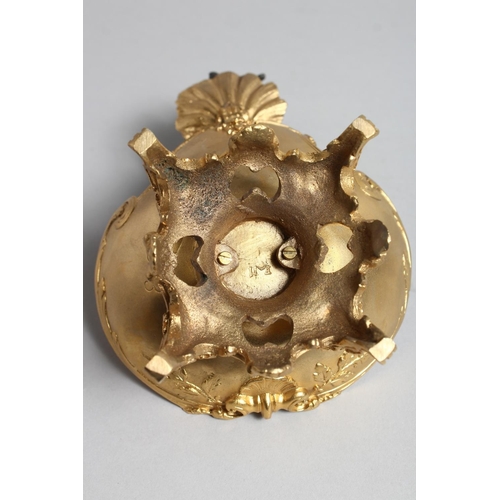 1274 - A GILT BRONZE TABLE SALT mounted with a cherub. 7ins high.