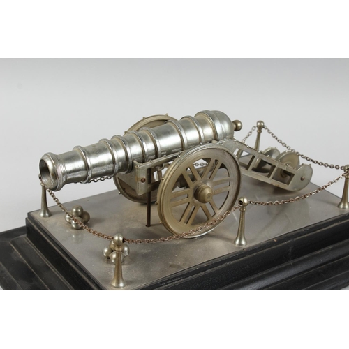 1329 - A GOOD CAST METAL MODEL OF A CANNON, on its wheeled carriage, on an ebonised plinth base. 1ft 6ins l... 