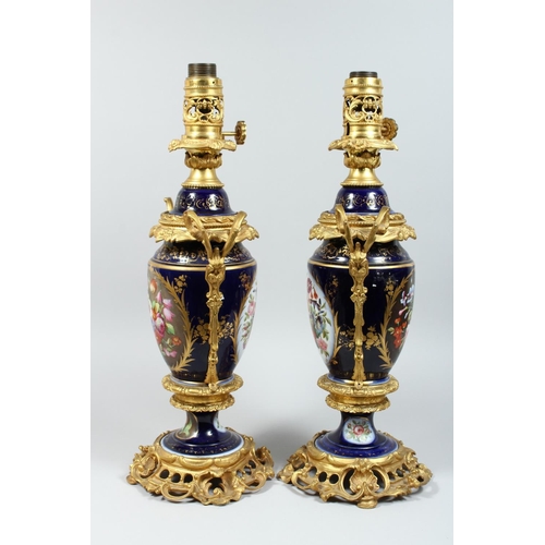 1335 - A PAIR OF PARIS PORCELAIN AND ORMOLU MOUNTED URN SHAPED TABLE LAMPS, painted with panels of flowers ... 