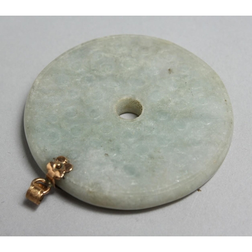 1705 - A CHINESE CIRCULAR JADE PENDANT with gold mounts, 2.25ins diameter.