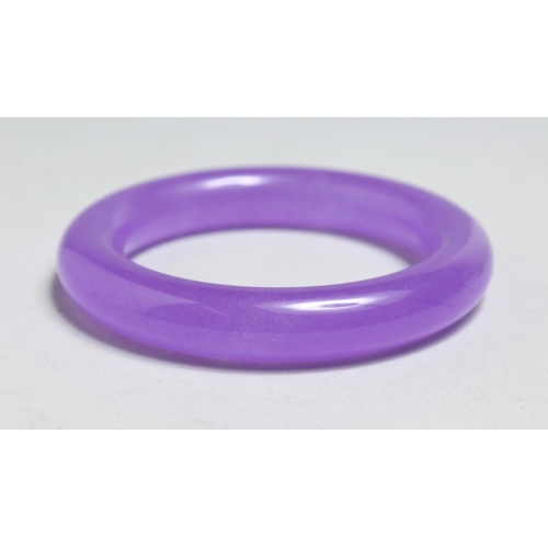 1709 - A CHINESE LAVENDER JADE BANGLE, 3.5ins diameter.