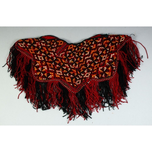 28 - A TURKAMAN BABY PONCHO, all over embroidered design with fringed edge, approx. 37cm diameter.