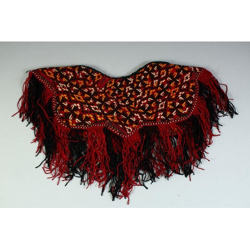 28 - A TURKAMAN BABY PONCHO, all over embroidered design with fringed edge, approx. 37cm diameter.