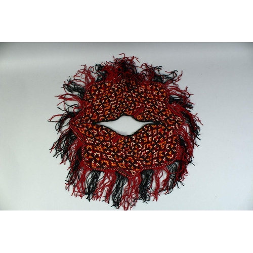 28 - A TURKAMAN BABY PONCHO, all over embroidered design with fringed edge, approx. 37cm diameter.