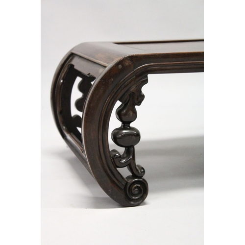 693 - A CHINESE ROSEWOOD LOW TABLE WITH PANELLED TOP, supported on curving ends with pierced and carved br... 