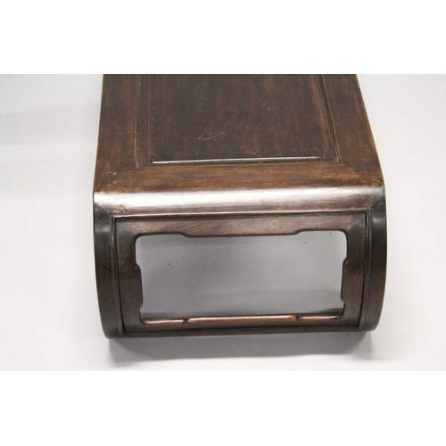 693 - A CHINESE ROSEWOOD LOW TABLE WITH PANELLED TOP, supported on curving ends with pierced and carved br... 