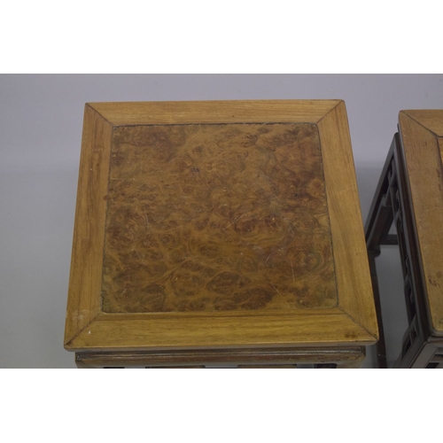 694 - TWO GOOD CHINESE HARDWOOD SQUARE STANDS, each inset with a burr wood panel, above a carved frieze su... 