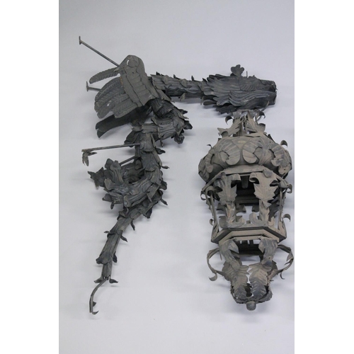 1044 - AN UNUSUAL PAIR OF WROUGHT IRON SCULPTURE LANTERNS with dragon supports. Overall height 4ft.