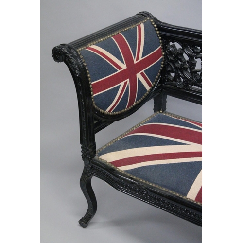 1053 - A VICTORIAN STYLE BLACK PAINTED SCROLL END SETTEE, upholstered with a Union Jack fabric. 5ft long x ... 