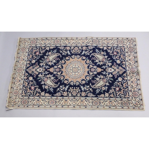 1067 - A PERSIAN RUG blue ground with central loral medallion within a cream ground floral border. 6ft 9ins... 