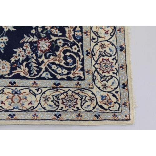 1067 - A PERSIAN RUG blue ground with central loral medallion within a cream ground floral border. 6ft 9ins... 