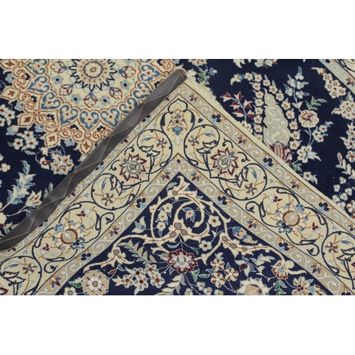 1067 - A PERSIAN RUG blue ground with central loral medallion within a cream ground floral border. 6ft 9ins... 