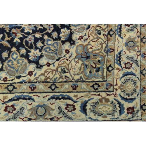 1068 - A PERSIAN RUG blue ground with central loral medallion within a cream ground floral border. 6ft 6ins... 