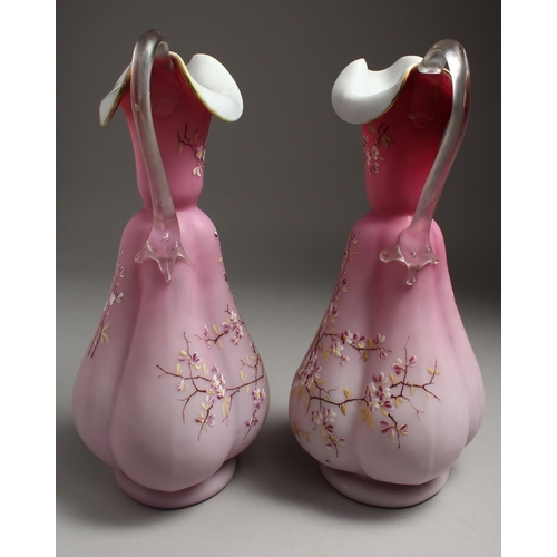 1086 - A PAIR OF SATIN GLASS JUGS painted with flowers. 12ins high.