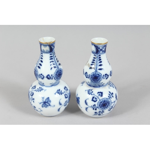 1167 - A SMALL PAIR OF MEISSEN ONION PATTERN BOTTLE VASES. Cross swords mark in blue, 4.5ins high.