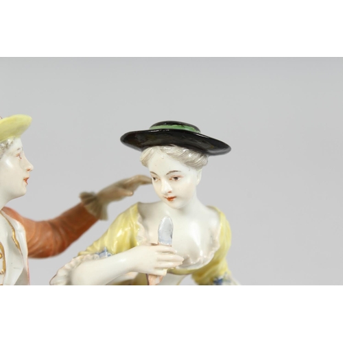 1174 - A GOOD FURSTENBERG PORCELAIN GROUP of a young man and girl siting on a bench, a basket of grapes at ... 