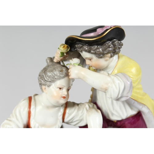 1175 - A GOOD MEISSEN PORCELAIN GROUP OF A BOY AND GIRL with garlands of flowers on an oval base. Cross swo... 