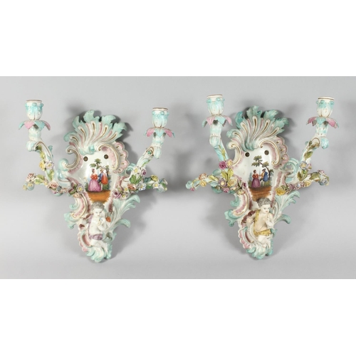 1189 - A GOOD PAIR OF MEISSEN PORCELAIN TWO BRANCH WALL SCONCES enamelled with flowers and cupids. Cross sw... 