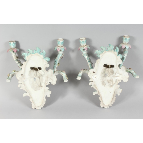 1189 - A GOOD PAIR OF MEISSEN PORCELAIN TWO BRANCH WALL SCONCES enamelled with flowers and cupids. Cross sw... 