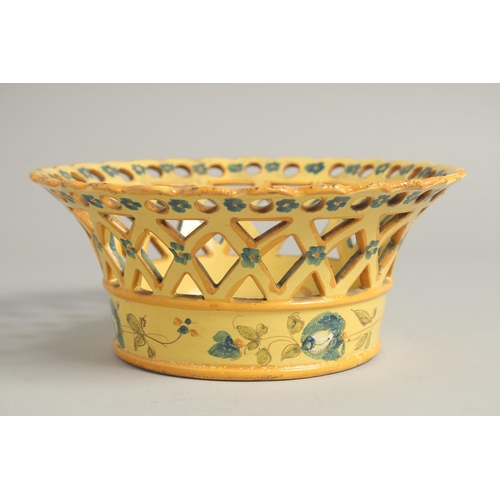 1211 - A CONTINENTAL YELLOW GROUP PIERCED CIRCULAR BASKET painted with flowers. 8ins diameter.