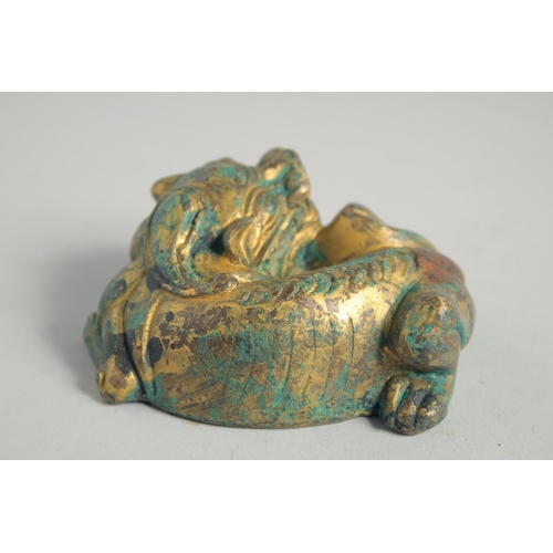 1237 - A CHINESE GILDED METAL LION LYING DOWN. 7cm long.