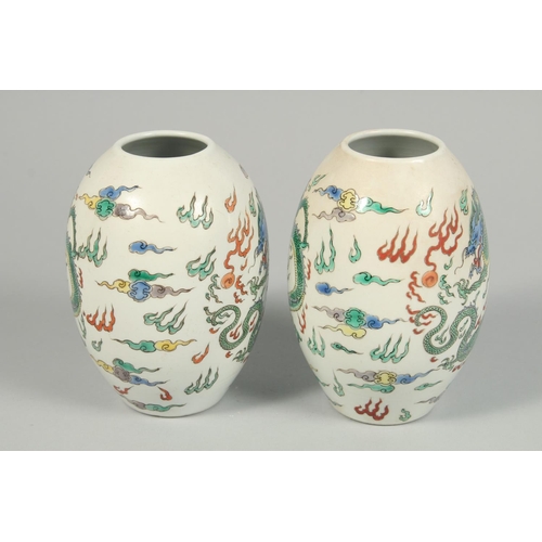 1247 - A PAIR OF CHINESE VASES decorated with dragons. 8.5ins high.