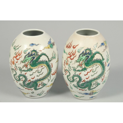 1247 - A PAIR OF CHINESE VASES decorated with dragons. 8.5ins high.