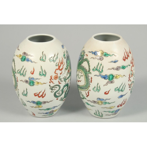 1247 - A PAIR OF CHINESE VASES decorated with dragons. 8.5ins high.