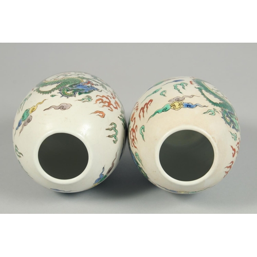 1247 - A PAIR OF CHINESE VASES decorated with dragons. 8.5ins high.