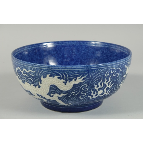 1250 - A CHINESE BLUE BOWL the sides with white dragons. 10ins diameter.