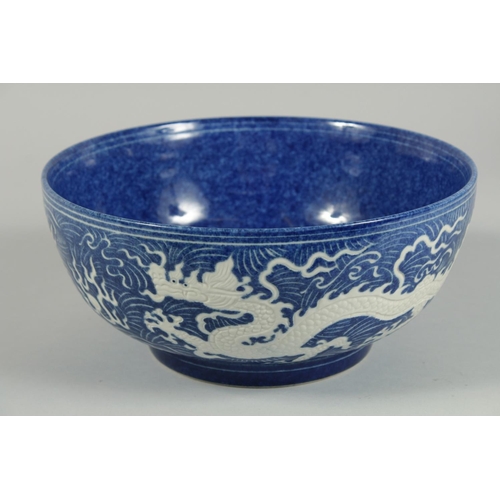 1250 - A CHINESE BLUE BOWL the sides with white dragons. 10ins diameter.