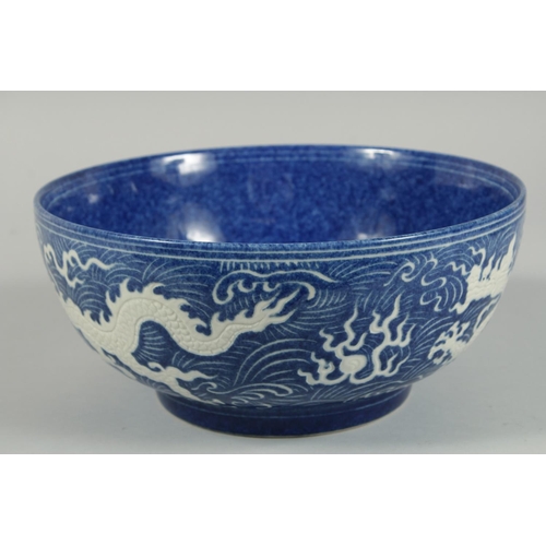 1250 - A CHINESE BLUE BOWL the sides with white dragons. 10ins diameter.