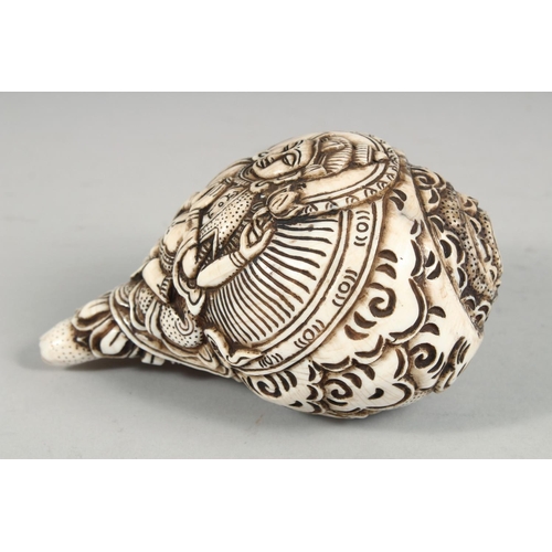 1253 - A LARGE CARVED CONCH SHELL WITH HINDU GOD. 16cm long.