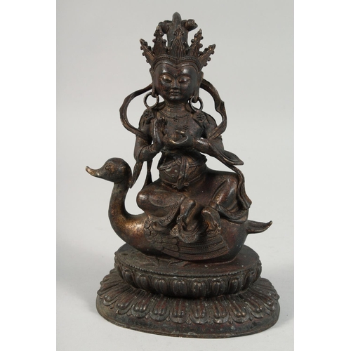 1255 - A LARGE BRONZE FIGURE OF A SEATED DEITY, sat upon a bird and on a lotus base, with traces of gilt, 2... 