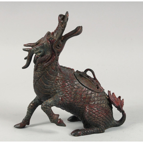 1257 - A CHINESE BRONZE DRAGON FORM CENSER, with traces of red paint, lid section to the back, 24cm high.