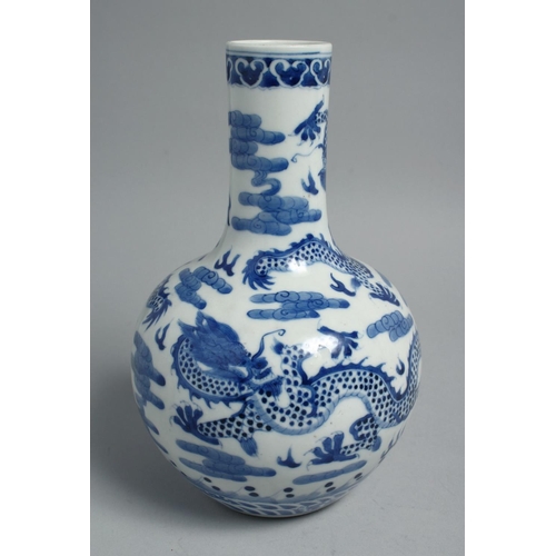 1260 - A CHINESE BLUE AND WHITE PORCELAIN BOTTLE VASE, painted with dragons and the flaming pearl of wisdom... 