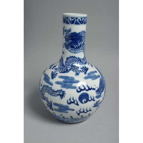 1260 - A CHINESE BLUE AND WHITE PORCELAIN BOTTLE VASE, painted with dragons and the flaming pearl of wisdom... 