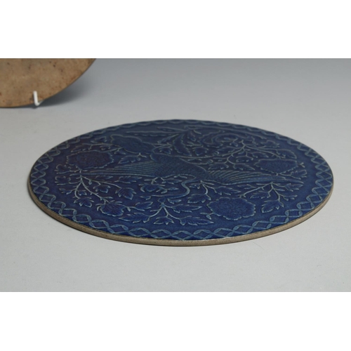 1261 - A PAIR OF CHINESE BLUE GLAZED CIRCULAR PLAQUES, one carved with a dragon, the other with an exotic b... 