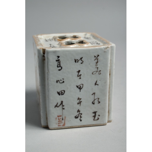 1264 - A CHINESE PORCELAIN INKWELL, painted with figures and script. 10cm wide.