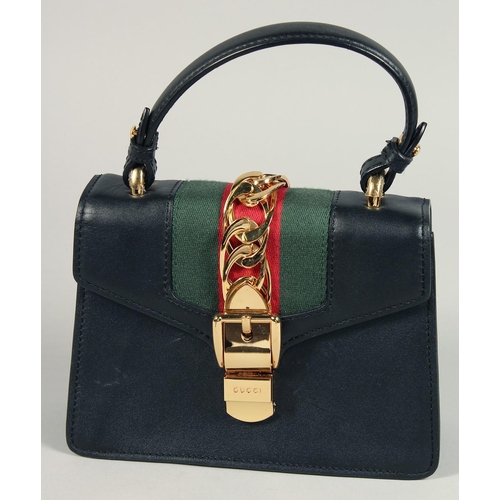 1547 - A GOOD GUCCI SMALL CLUTCH BAG 7.5ins x 5.5ins with gilt Gucci lock and leather handles.