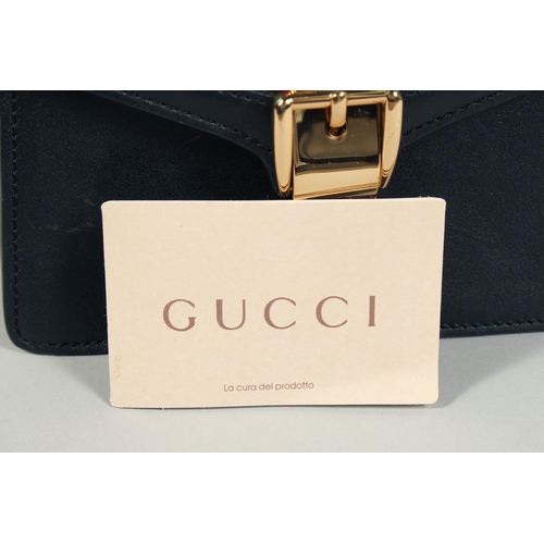 1547 - A GOOD GUCCI SMALL CLUTCH BAG 7.5ins x 5.5ins with gilt Gucci lock and leather handles.