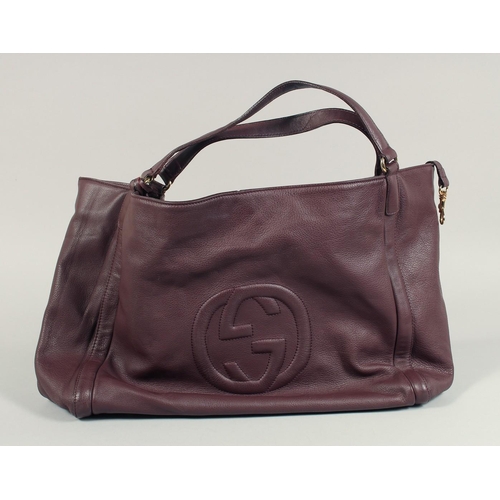 1551 - A LARGE GUCCI MAROON LEATHER SOFT BAG, 'G' on the side. 18ins x 12 ins with two leather handles.