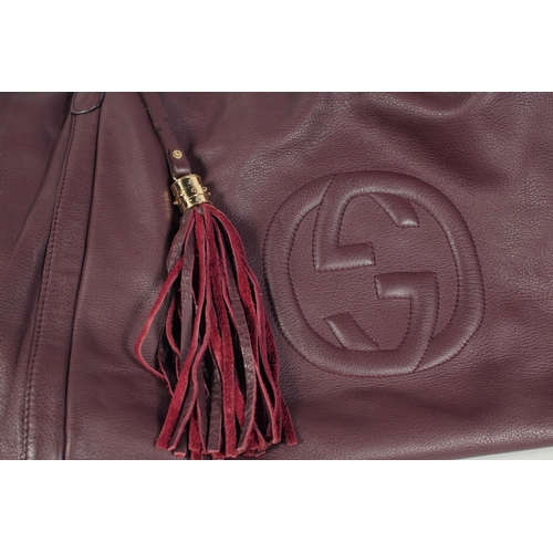 1551 - A LARGE GUCCI MAROON LEATHER SOFT BAG, 'G' on the side. 18ins x 12 ins with two leather handles.