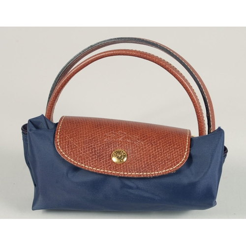 1554 - A LONGCHAMP FOLDING TOTE BAG. 7ins x 3.5 with two handles.