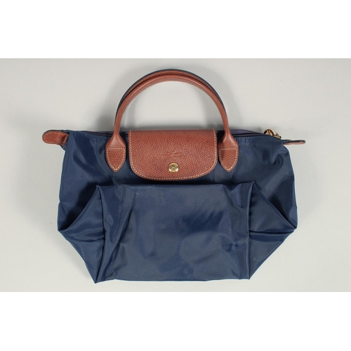 1554 - A LONGCHAMP FOLDING TOTE BAG. 7ins x 3.5 with two handles.