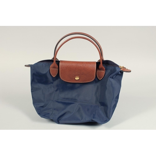 1554 - A LONGCHAMP FOLDING TOTE BAG. 7ins x 3.5 with two handles.