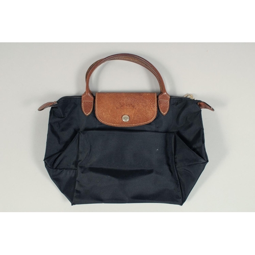 1555 - A LONGCHAMP FOLDING TOTE BAG. 7ins x 3.5 with two handles.